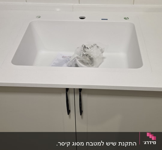 משטח שיש לבן חדש עם כיור מותקן וארון מטבח
